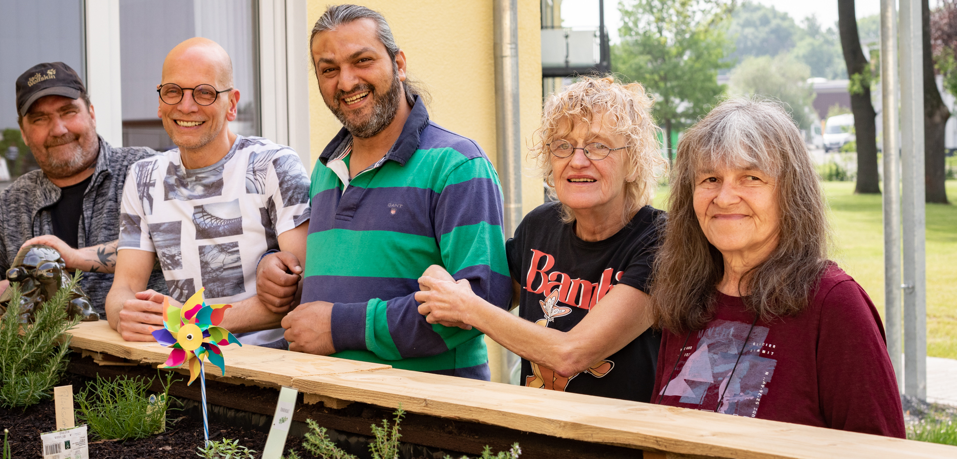 Bewohner:innen mit Pflegekraft am Hochbeet vor dem Wohnhaus Karl-Winkelmann in Werl.