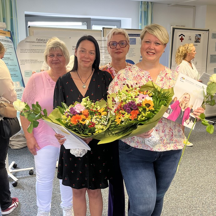 Bild mit drei Personen mit Blumenstrauß in der Hand